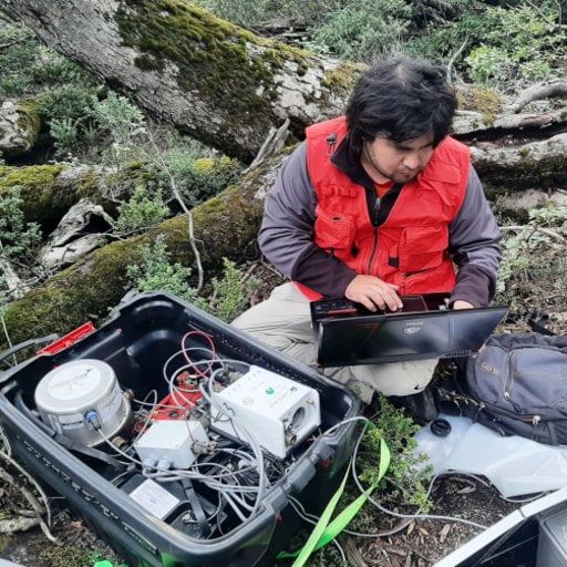 Persona trabajando con equipo geofísico en terreno natural